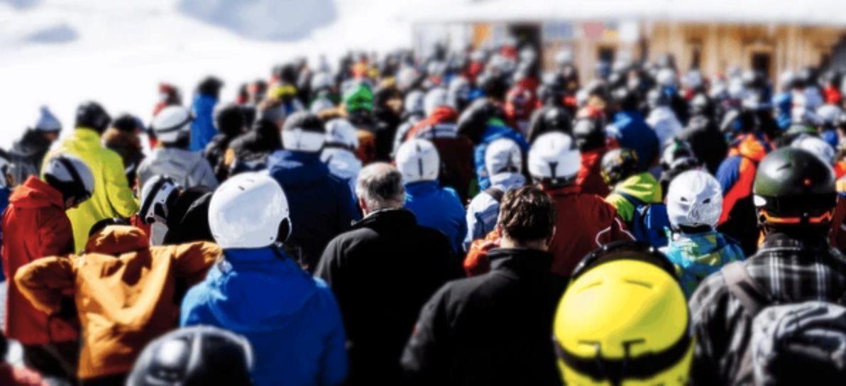 Image : Une grande foule de skieurs faisant la queue devant une remontée mécanique.
